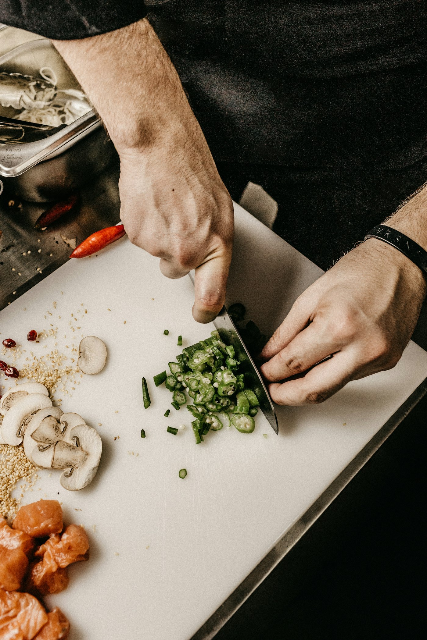 A chef seasoning food in a professional kitchen