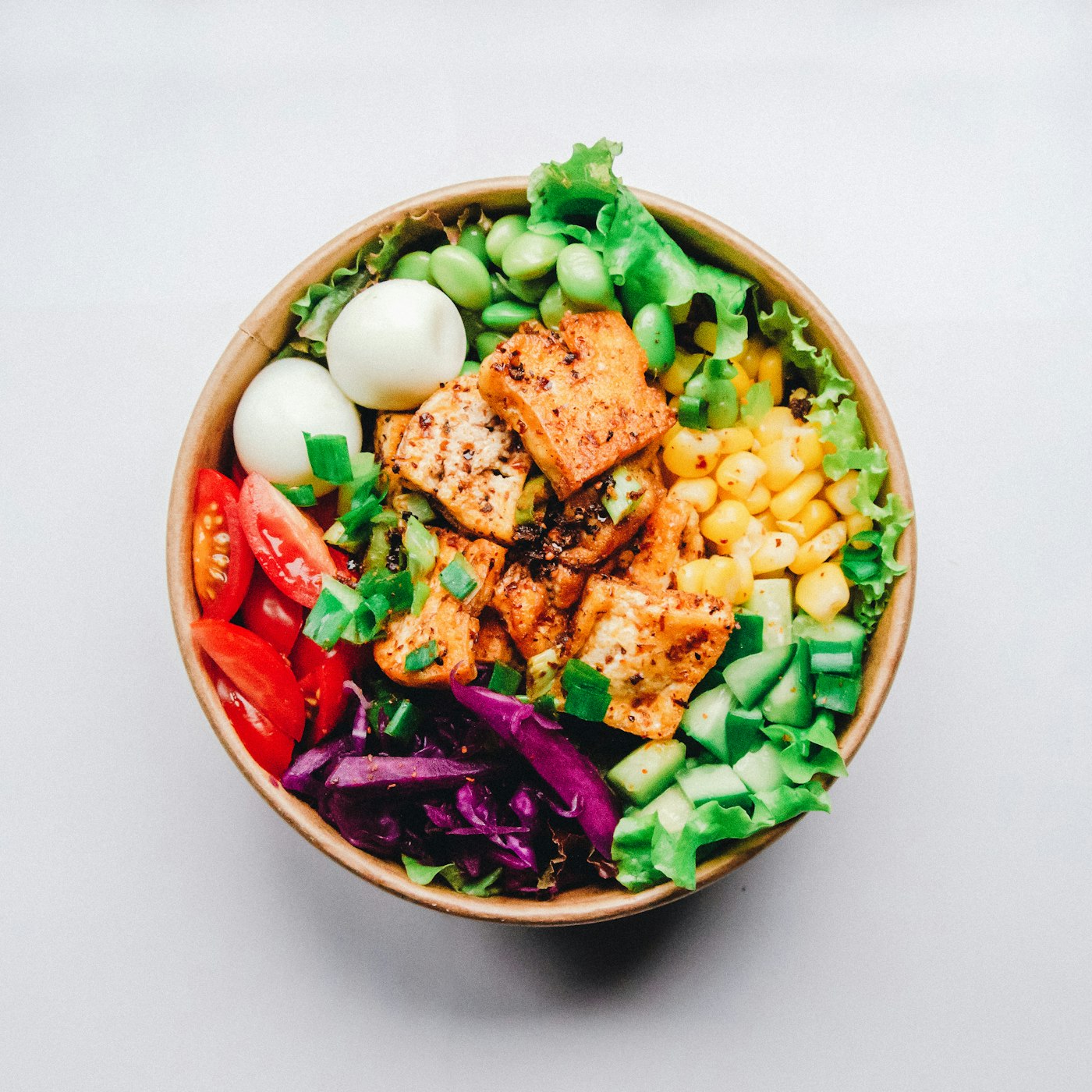 A grain bowl with avocado, egg, and vegetables